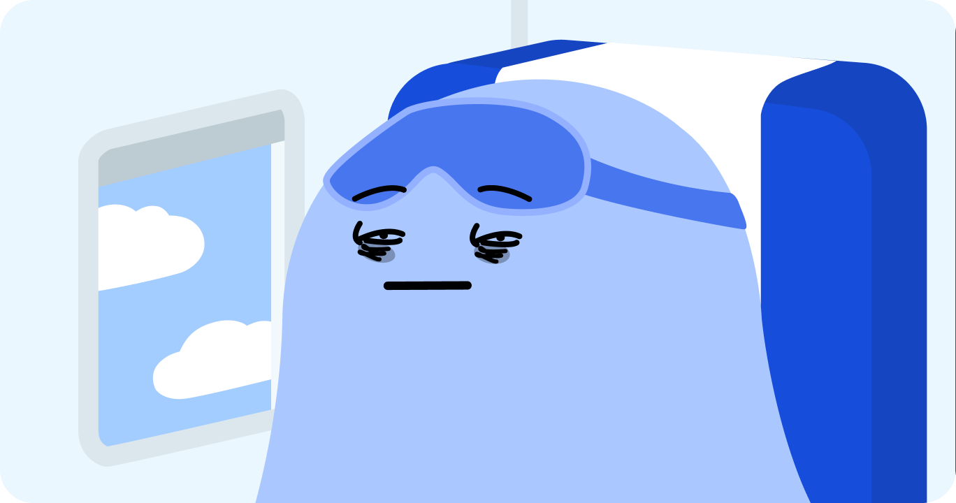 飛行機の中でネックピローを使って眠っている人